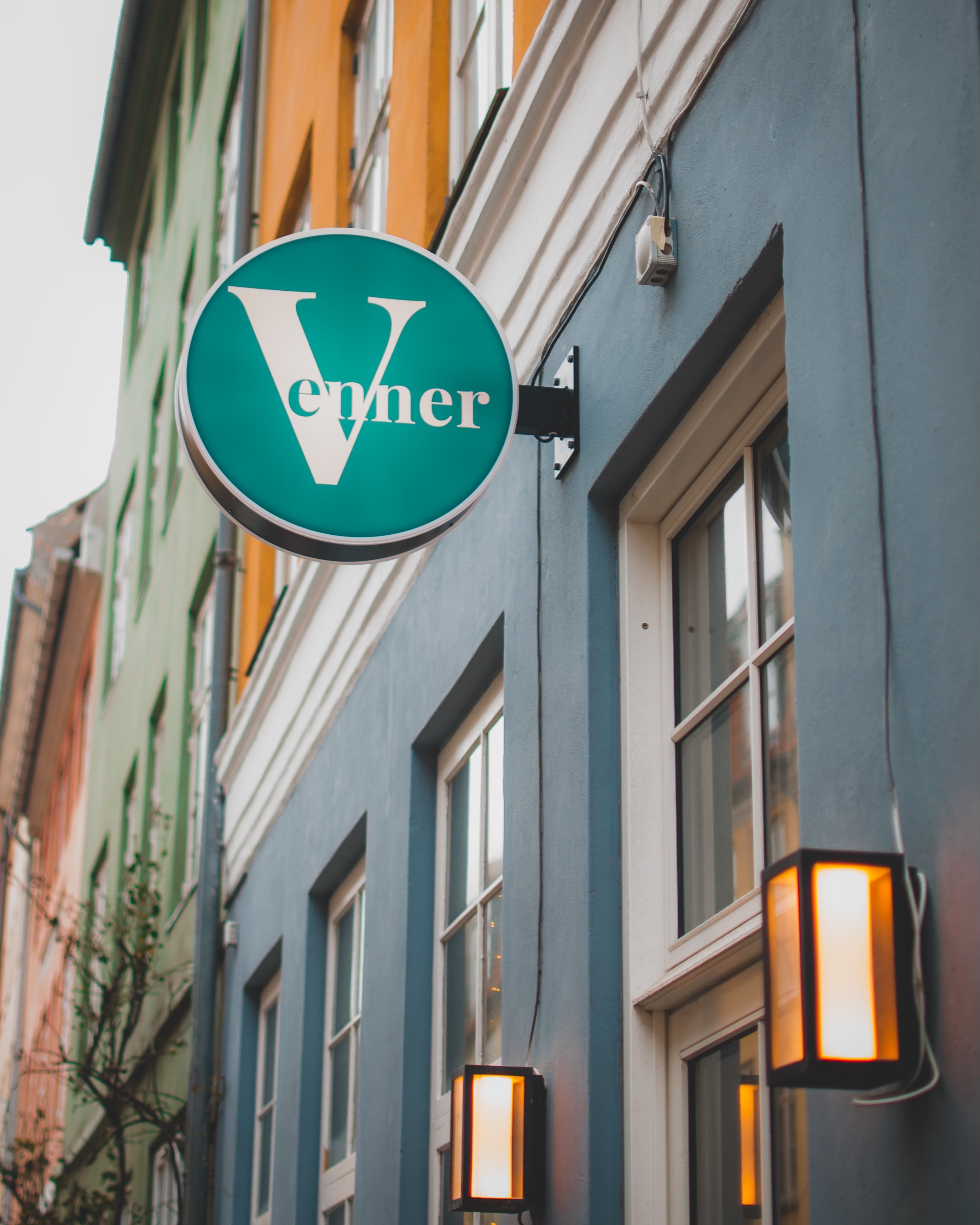 Venner restaurant exterior with iconic teal sign on charming Copenhagen street